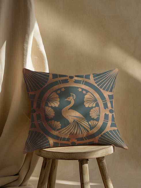 Square pillow cover featuring a stylized copper peacock design centered in a medallion, surrounded by Art Deco fan patterns and shell motifs on a dark forest green background.